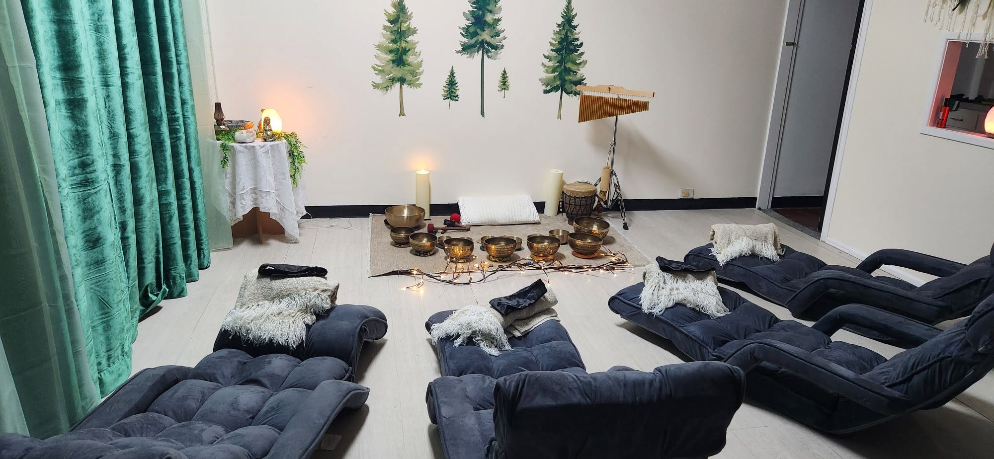 The Wilderness Rooftop Studio in Redcliffe with blue velvet loungers, tree wall decals, and Tibetan singing bowls arranged on mats