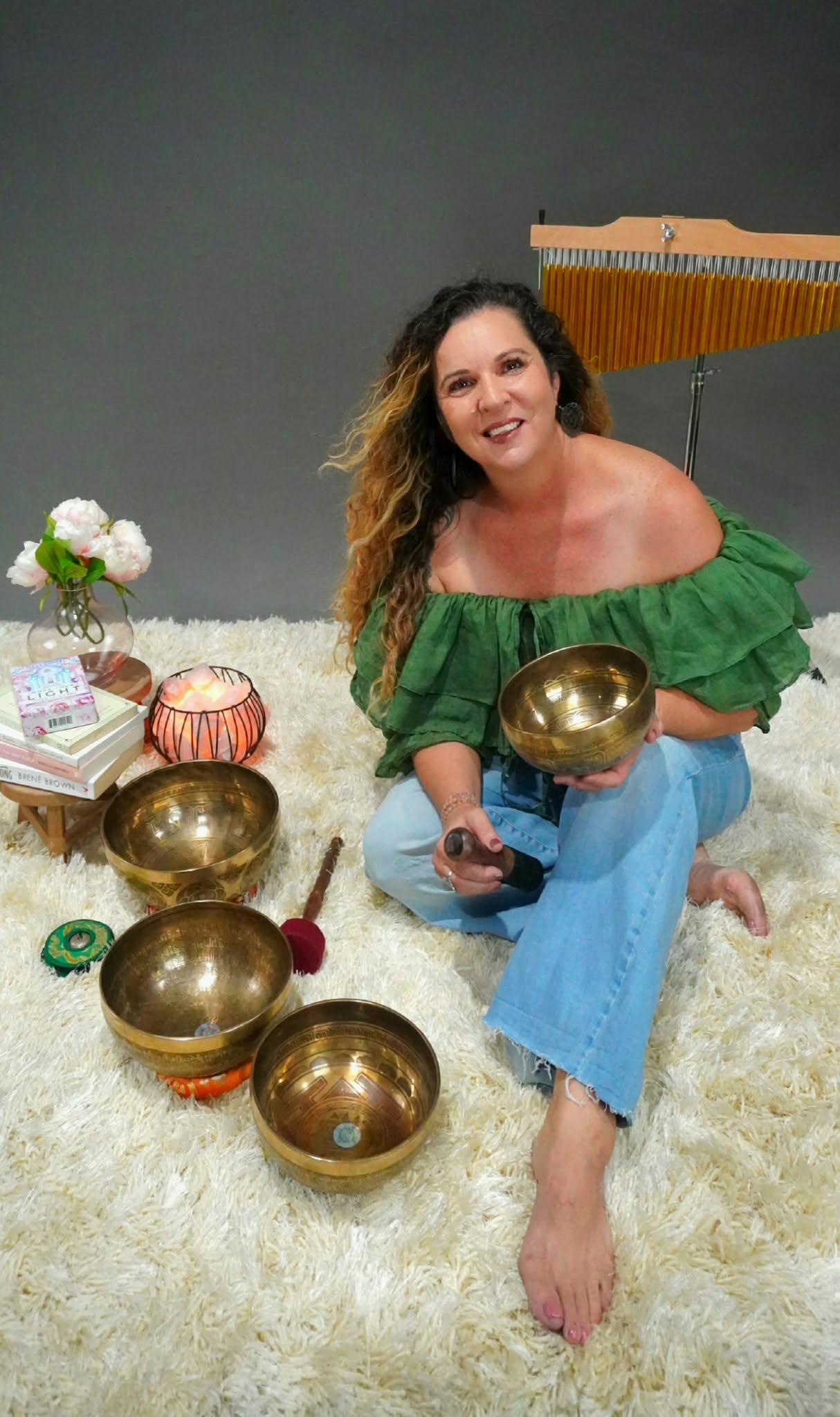 Narelle, sound healing practitioner, sitting with Tibetan singing bowls